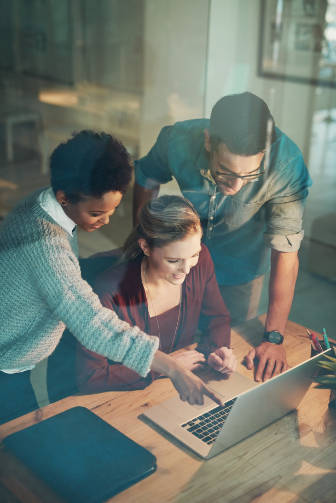 Business people, laptop and team in night for planning, strategy and project in office at seo company. Man, women and happiness for results, goal and work overtime for problem solving in workplace